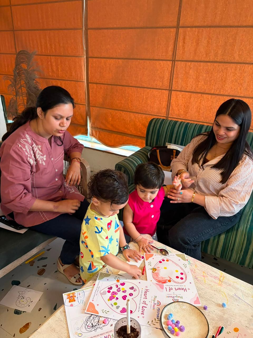 Two moms and their little ones enjoying a hands-on Play & Pause playdate together