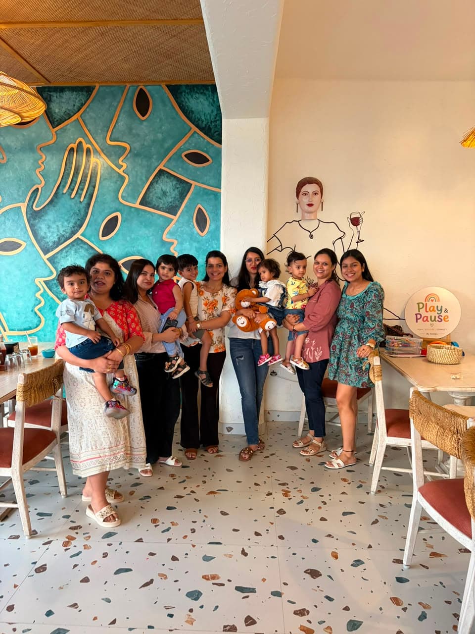 Moms and toddlers gathered for a group photo in front of a mural at a Play & Pause playdate in Jaipur